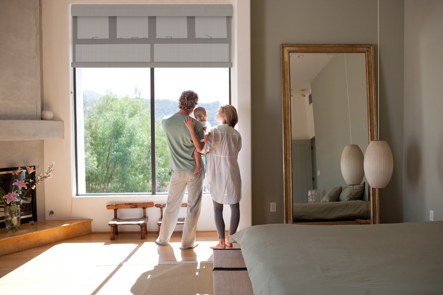 A family looking out a window in a bedroom.